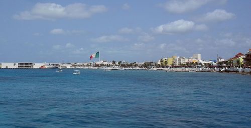 Scenic view of sea by buildings against sky