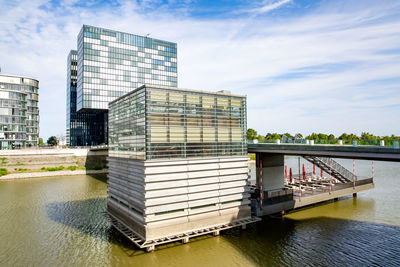 Built structure by river against sky