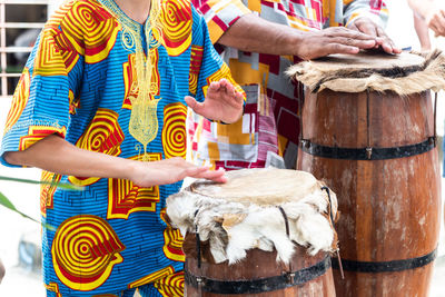 Members of candomble are playing a percussion instrument during a religious demonstration 