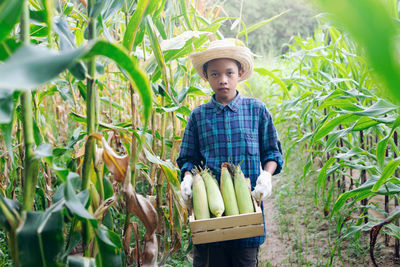 Portrait of boy standing by plants