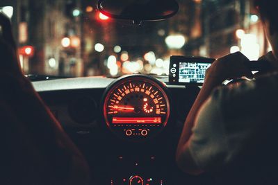 Rear view of man driving car at night