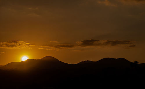 Scenic view of silhouette mountains against sky during sunset