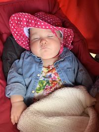 Cute baby girl in a pink summer hat sleeping in a pram 
