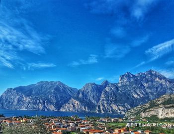 Panoramic view of buildings and mountains against blue sky