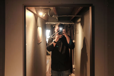 Reflection of man photographing in mirror