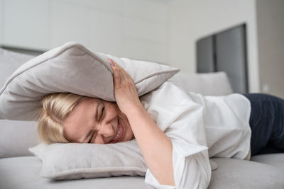 Portrait of woman lying on bed at home