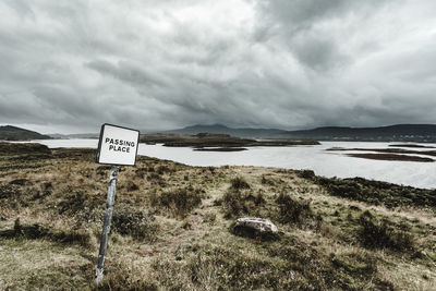 Information sign on landscape against sky