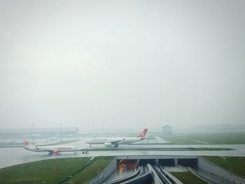 Airplane on airport runway against sky