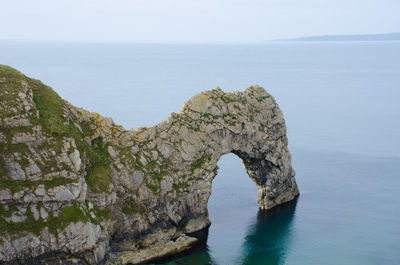 Rock formations by sea against sky