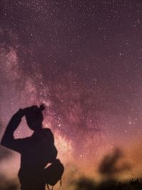 Silhouette of man against star field at night