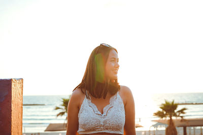 Portrait of beautiful woman against sea against clear sky