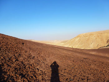 Scenic view of desert against clear blue sky