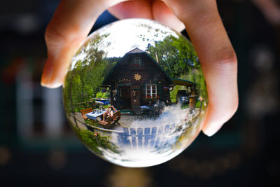 Close-up of hand holding crystal ball with reflection