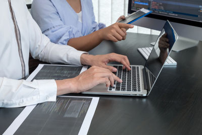 Midsection of doctor using laptop at clinic