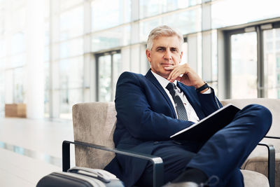 Mid adult man sitting on chair at home