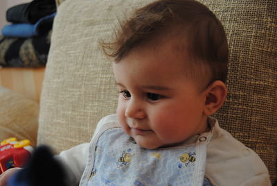 Close-up of cute baby boy looking down at home