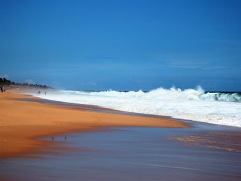 Scenic view of beach against blue sky