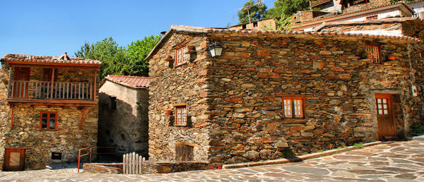 Exterior of old building by house against sky