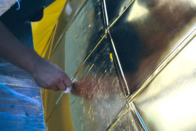 Close-up of man working against wall