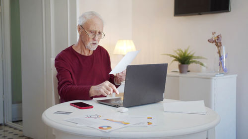 Senior man working on laptop at home