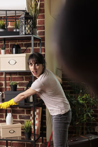 Side view of young woman standing by railing