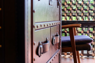 Close-up of chairs on table by window