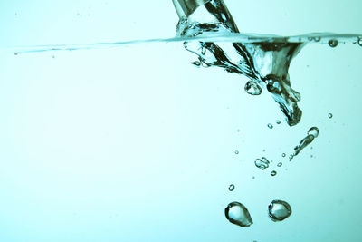 Close-up of water splashing against blue background