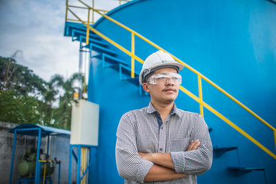 Portrait of man wearing hat standing against blue sky