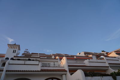 Low angle view of buildings against clear blue sky