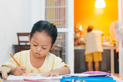 Close-up of girl drawing at home