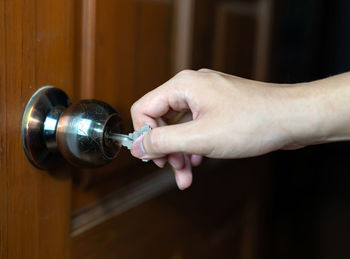 Close-up of hand holding metallic door