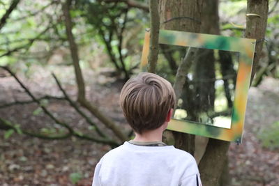 Rear view of boy in forest