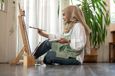 Portrait of young woman sitting on floor