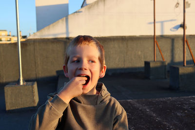 Young man looking away while standing outdoors