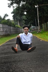 Portrait of young man sitting on field