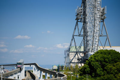 Low angle view of ferris wheel and bridge against sky