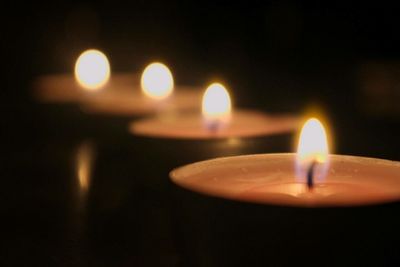 Close-up of lit candle in dark room
