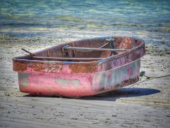 Abandoned boat moored on shore