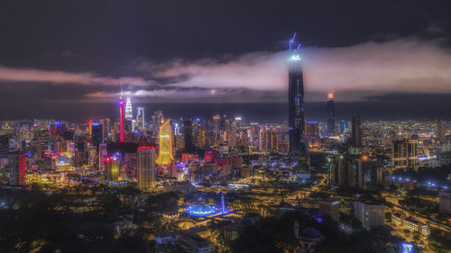 Illuminated buildings against sky at night