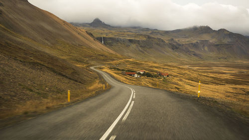 Road leading towards mountains against sky