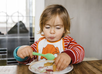 Cute girl eating food at home