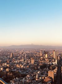 High angle view of city buildings against clear sky during sunset