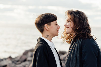 Couple kissing against sea and sky