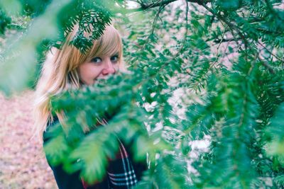 Portrait of woman standing against plants