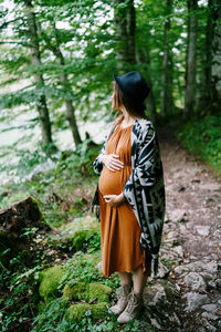 Rear view of woman walking in forest