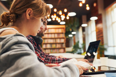 Students learning in university library. young woman preparing for test girl learning from computer