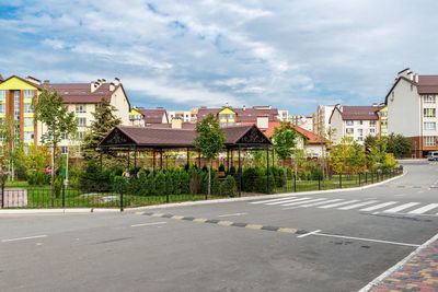 Pedestrian crossing and road against the background of a residential complex with a park