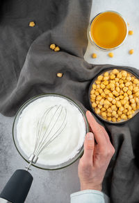 Chickpea aquafaba. egg replacement. vegan cooking concept. men hands whippe whisk chickpeas liquid 