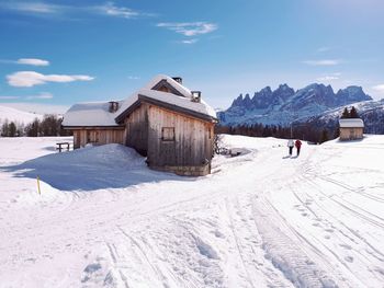 Houses on snow field against sky