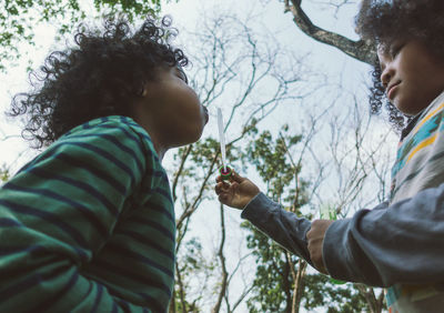 Close-up of father holding daughter against trees